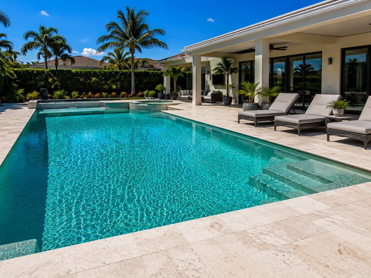 Resurfaced rectangular pool with an integrated spa and travertine deck at a Loxahatchee acreage property