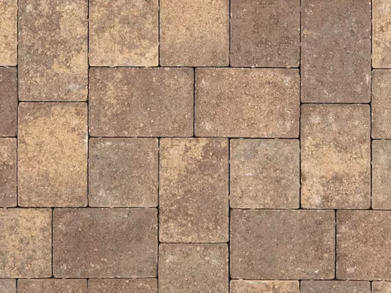 Close up of tumbled brick pavers in blended tan and brown earth tones laid in a modular pattern